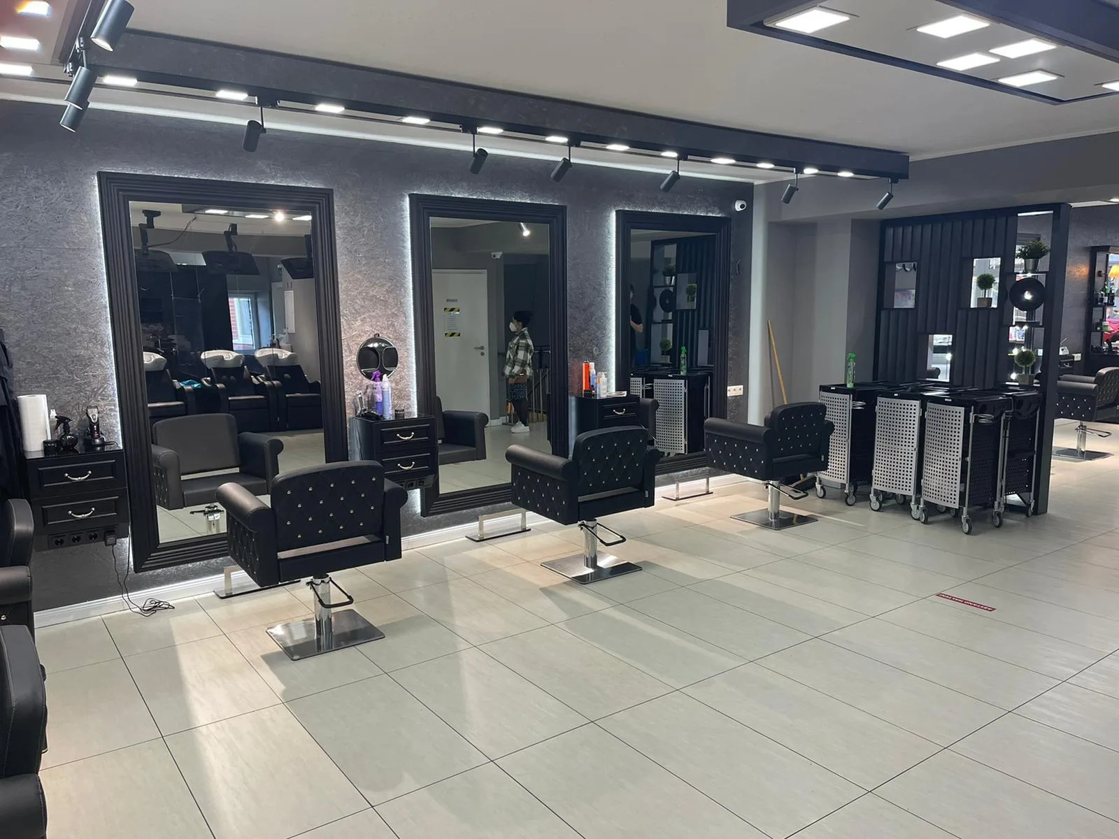Weitwinkelansicht des Salons mit einer Reihe beleuchteter Spiegelplätze
